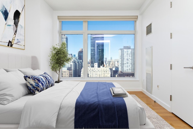 400 E 67th St Unit 20B, New York City, NY 10065 - bedroom with wood finished floors and a view of skyline