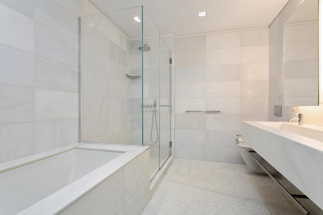 400 E 67th St Unit 20B, New York City, NY 10065 - bathroom featuring a shower stall, tile walls, a garden tub, tile patterned floors, and vanity