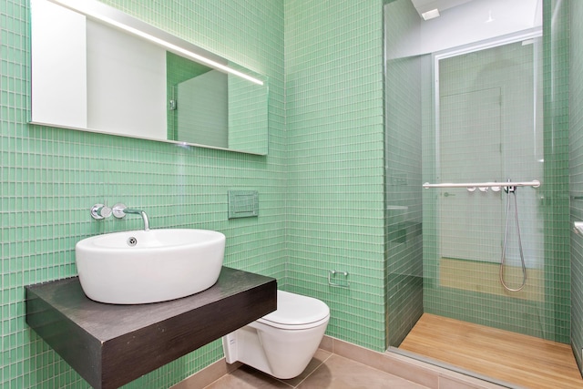 400 E 67th St Unit 20B, New York City, NY 10065 - bathroom with tile walls, a tile shower, and tile patterned floors