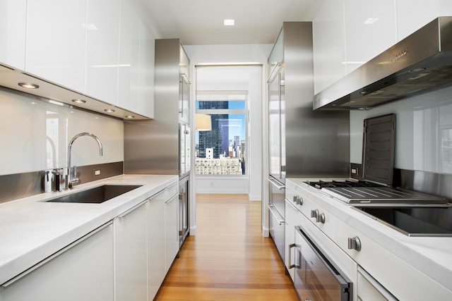400 E 67th St Unit 20B, New York City, NY 10065 - kitchen featuring range hood, modern cabinets, and light wood finished floors