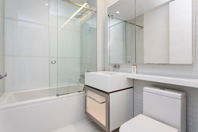 400 E 67th St Unit 20B, New York City, NY 10065 - full bathroom with tile walls, vanity, and shower / bath combination with glass door