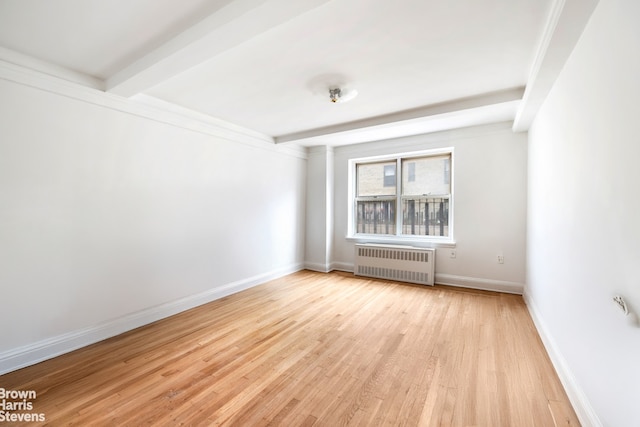 433 E 51st St Unit 11E, New York City, NY 10022 - empty room featuring radiator heating unit, beam ceiling, and light wood finished floors