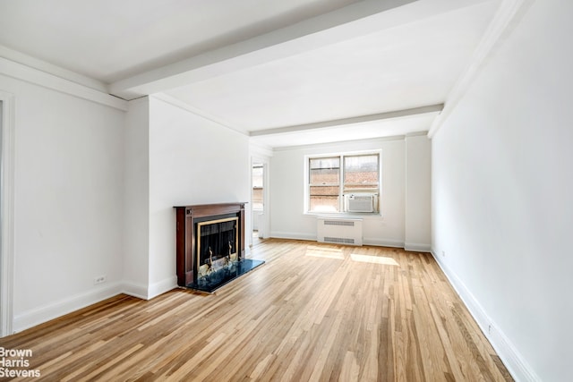 433 E 51st St Unit 11E, New York City, NY 10022 - unfurnished living room featuring radiator heating unit, a fireplace with raised hearth, light wood-style flooring, and cooling unit