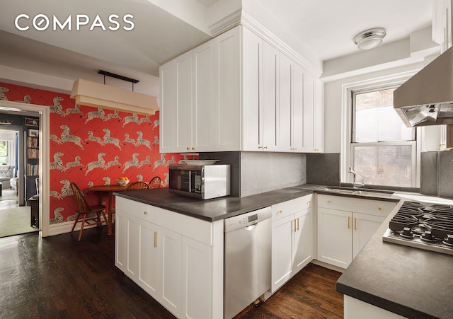 163 E 81st St Unit 3A, New York City, NY 10028 - kitchen featuring stainless steel appliances, dark countertops, plenty of natural light, dark wood-style flooring, and wallpapered walls