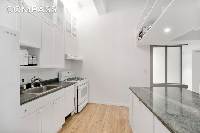 415 W 55th St Unit 4D, New York City, NY 10019 - kitchen with white appliances, under cabinet range hood, white cabinets, light wood-style flooring, and glass insert cabinets