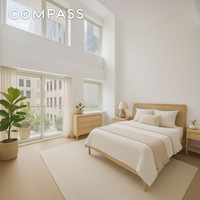 67 Liberty St Unit 10, New York City, NY 10005 - bedroom featuring multiple windows, a high ceiling, and wood finished floors