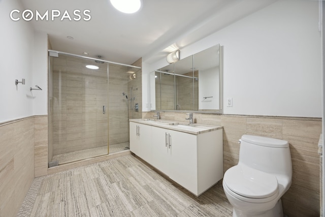 67 Liberty St Unit 10, New York City, NY 10005 - full bathroom featuring tile walls, double vanity, a stall shower, and wainscoting