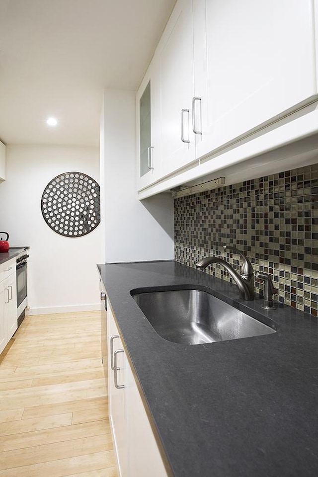 150 W 51st St Unit 1623, New York City, NY 10019 - kitchen with stove, tasteful backsplash, white cabinetry, recessed lighting, and light wood-style flooring