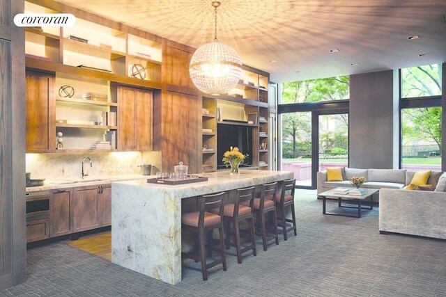 200 E 94th St Unit 405, New York City, NY 10128 - kitchen featuring open shelves, a kitchen island, a kitchen breakfast bar, a chandelier, and floor to ceiling windows