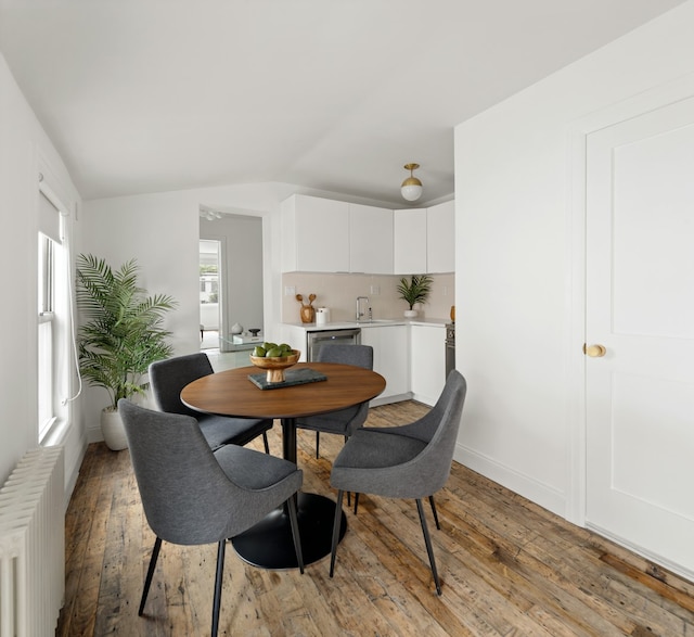 211 Powers St, New York City, NY 11211 - dining space with lofted ceiling, radiator, and light wood-style floors