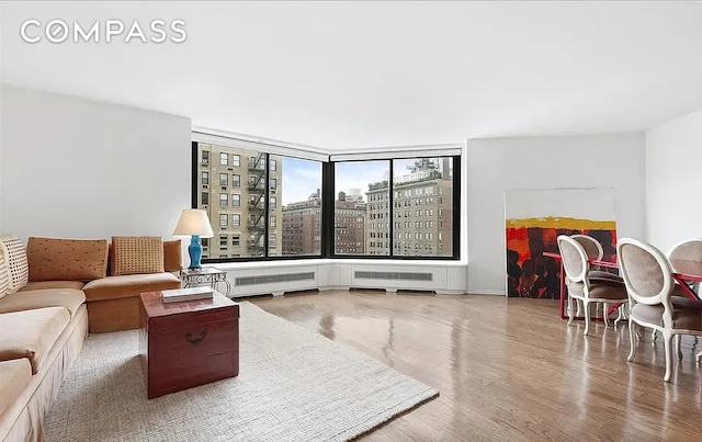 40 E 94th St Unit 13G, New York City, NY 10128 - living area with a view of city, wood finished floors, and radiator