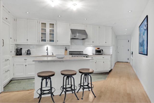 242 E 7th St Ph, Ph, New York City, NY 10009 - kitchen featuring range hood, stove, tasteful backsplash, light countertops, and white cabinets