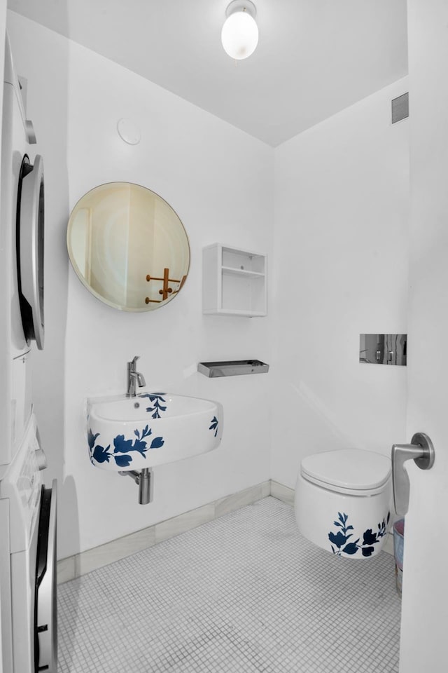 242 E 7th St Ph, Ph, New York City, NY 10009 - bathroom with stacked washer / dryer and tile patterned flooring