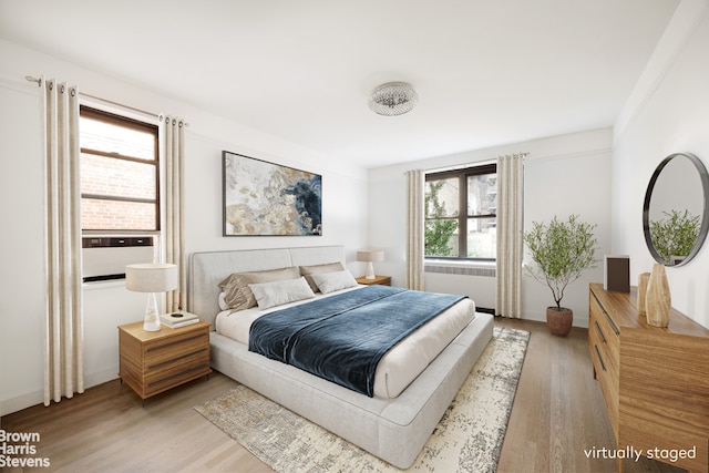 349 E 49th St Unit 6P, New York City, NY 10017 - bedroom with radiator heating unit and light wood-style floors