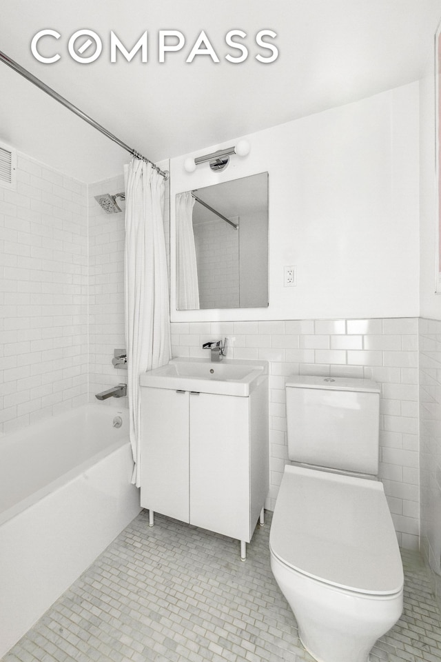 201 Clinton Ave Unit 10F, New York City, NY 11205 - full bathroom featuring tile walls, shower / tub combo with curtain, vanity, and tile patterned floors
