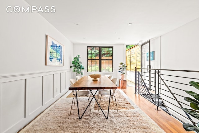 120 Pulaski St Unit 1B, New York City, NY 11206 - dining area with light wood-type flooring, a wainscoted wall, and a decorative wall