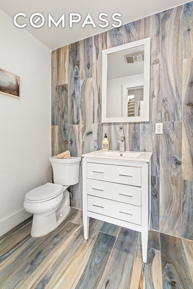 120 Pulaski St Unit 1B, New York City, NY 11206 - half bath featuring vanity and wood finished floors