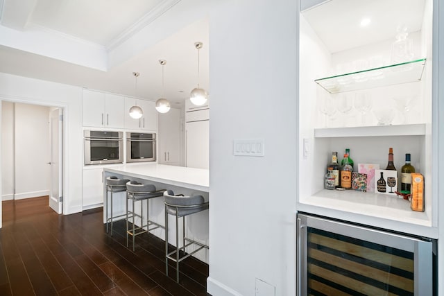 229 E 79th St Unit 7-B, New York City, NY 10075 - indoor dry bar with wine cooler, dark wood-style floors, crown molding, a tray ceiling, and pendant lighting