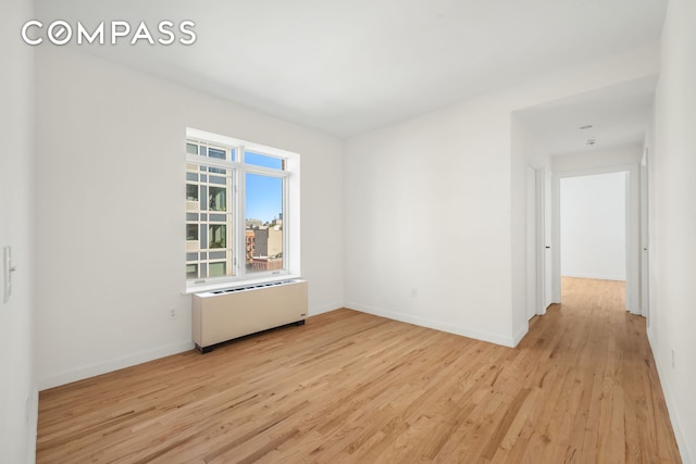 304 W 115th St Unit 6A, New York City, NY 10026 - unfurnished room with radiator and light wood finished floors