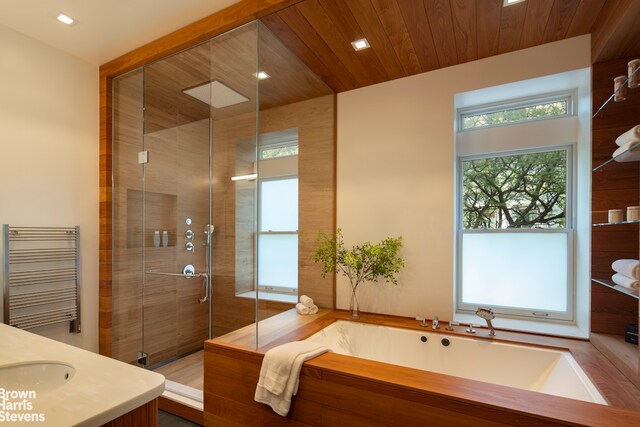 6 W 95th St, New York City, NY 10025 - full bath featuring radiator heating unit, a garden tub, a shower stall, vanity, and recessed lighting