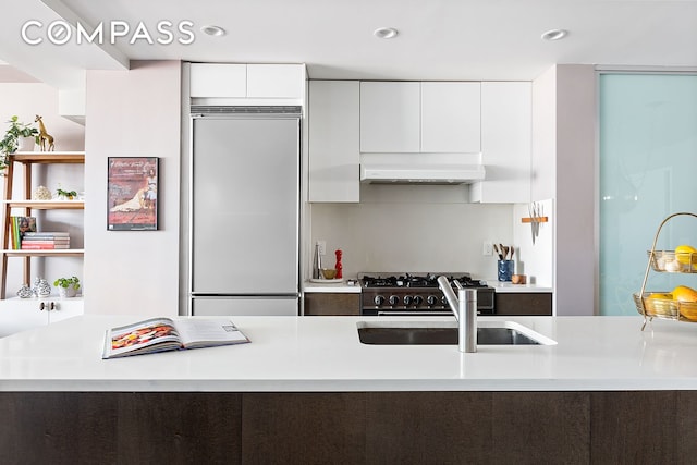 88 Morningside Ave Unit 8E, New York City, NY 10027 - kitchen with high quality appliances, modern cabinets, under cabinet range hood, white cabinets, and light countertops