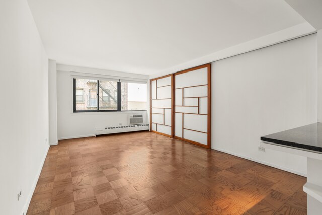 16 W 16th St Unit 7Rn, New York City, NY 10011 - empty room featuring a baseboard heating unit and a wall unit AC