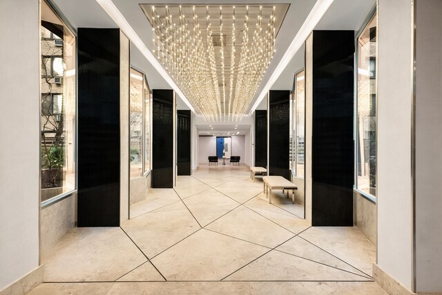 16 W 16th St Unit 7Rn, New York City, NY 10011 - corridor featuring a chandelier, tile patterned flooring, and a tray ceiling
