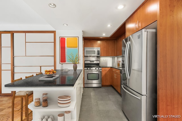 16 W 16th St Unit 7Rn, New York City, NY 10011 - kitchen with stainless steel appliances, brown cabinetry, recessed lighting, and a kitchen breakfast bar