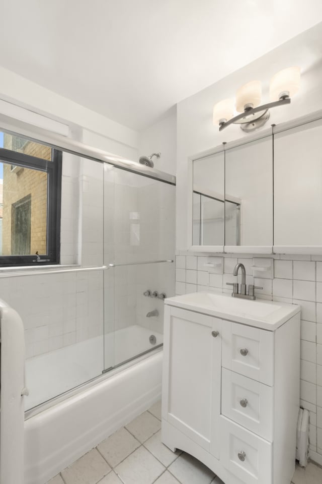 16 W 16th St Unit 7Rn, New York City, NY 10011 - bathroom with vanity, shower / bath combination with glass door, tile patterned flooring, and tile walls