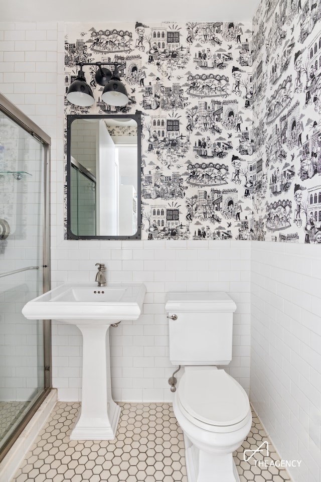 42 Main St Unit 2B, New York City, NY 11201 - full bathroom with wallpapered walls, tile walls, tile patterned floors, a shower stall, and wainscoting