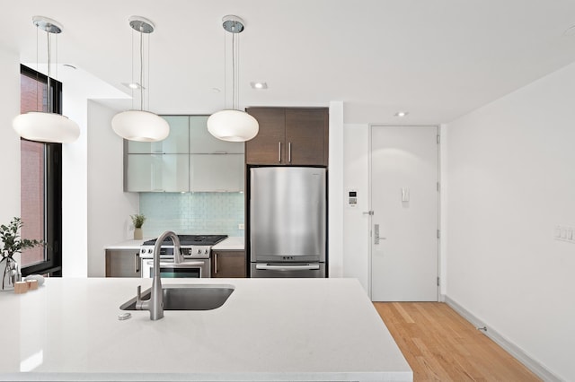 21-45 44th Dr Unit 4-C, New York City, NY 11101 - kitchen with stainless steel appliances, light countertops, modern cabinets, light wood-style floors, and tasteful backsplash