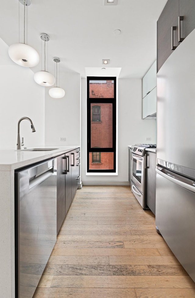 21-45 44th Dr Unit 4-C, New York City, NY 11101 - kitchen with appliances with stainless steel finishes, light wood-style flooring, modern cabinets, pendant lighting, and light countertops