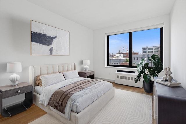 21-45 44th Dr Unit 4-C, New York City, NY 11101 - bedroom with radiator, wood finished floors, and a city view