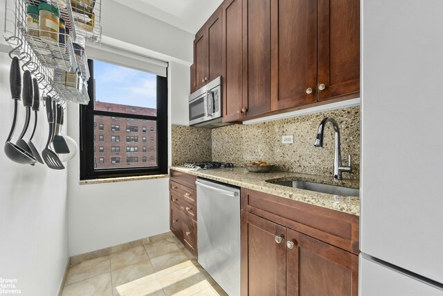 11 Riverside Dr Unit 14Ow, New York City, NY 10023 - kitchen with stainless steel appliances, tasteful backsplash, light stone countertops, and light tile patterned floors