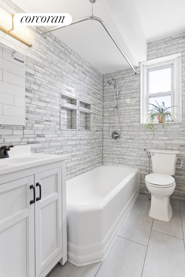 140 E 2nd St Unit 5T, New York City, NY 11218 - bathroom with tile patterned floors, tile walls, vanity, and shower / tub combination