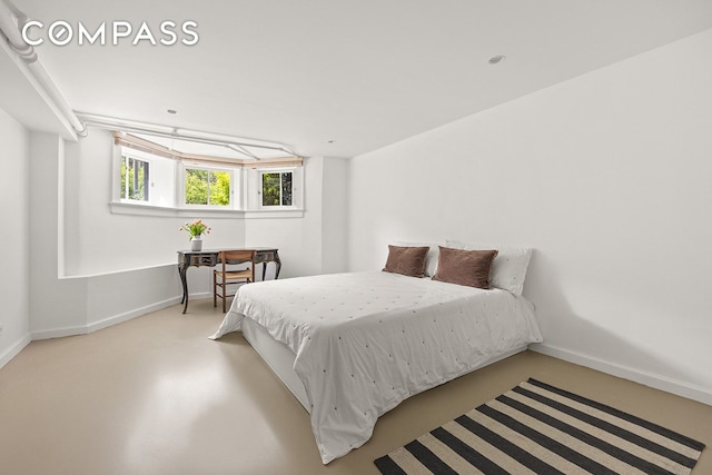 125 Rutland Rd, New York City, NY 11225 - bedroom featuring baseboards and finished concrete flooring