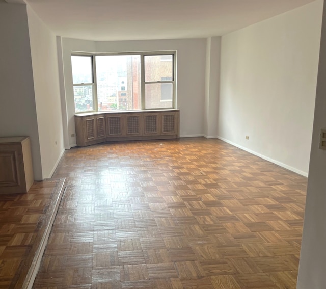 215 E 79th St Unit 12B, New York City, NY 10075 - empty room featuring baseboards and radiator heating unit