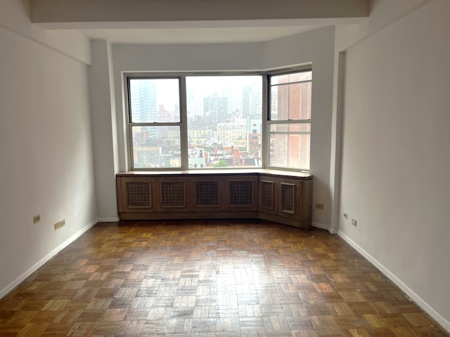 215 E 79th St Unit 12B, New York City, NY 10075 - unfurnished room featuring baseboards and a city view