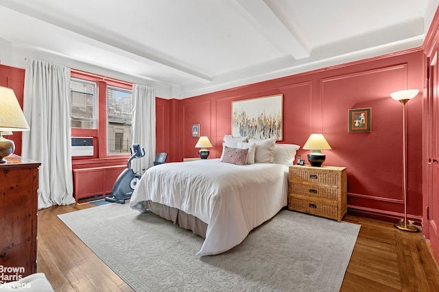 59 W 71st St Unit 4A, New York City, NY 10023 - bedroom featuring beamed ceiling, wood finished floors, a decorative wall, and cooling unit