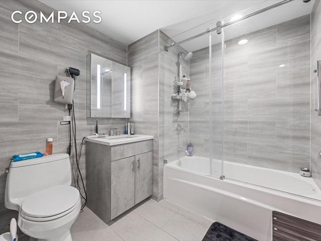 557 Hart St Unit 3A, New York City, NY 11221 - bathroom featuring tile patterned floors, shower / bath combination with glass door, vanity, and tile walls