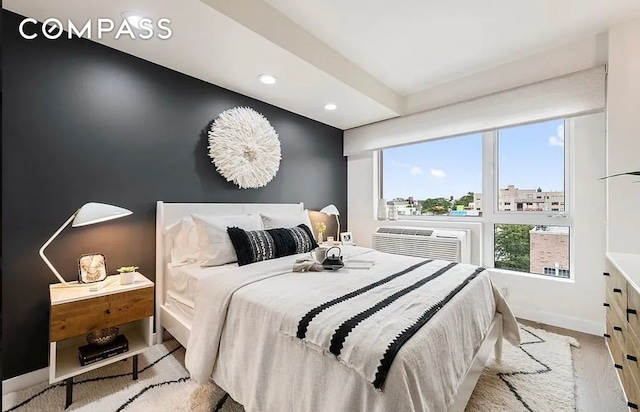 557 Hart St Unit 3A, New York City, NY 11221 - bedroom with a wall unit AC, wood finished floors, and recessed lighting