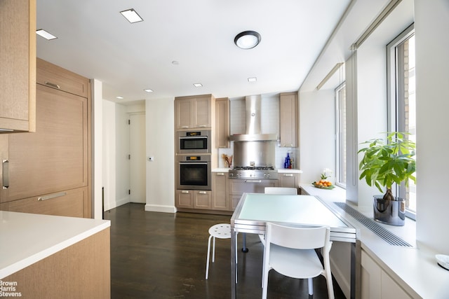 1212 5th Ave Unit 14A, New York City, NY 10029 - kitchen featuring wall chimney range hood, appliances with stainless steel finishes, light countertops, dark wood finished floors, and light brown cabinets