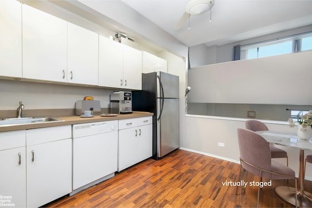 225 E 86th St Unit 801, New York City, NY 10028 - kitchen with white dishwasher, freestanding refrigerator, wood finished floors, light countertops, and white cabinetry