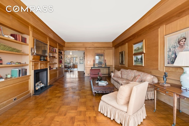 650 Park Ave Unit 18C, New York City, NY 10065 - living room featuring wood walls, a fireplace, and crown molding