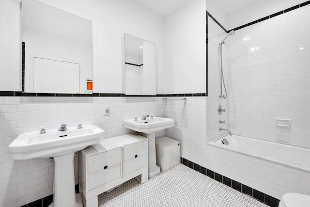 525 W 22nd St Unit 3Af, New York City, NY 10011 - bathroom featuring tiled shower / bath combo, tile patterned floors, and tile walls