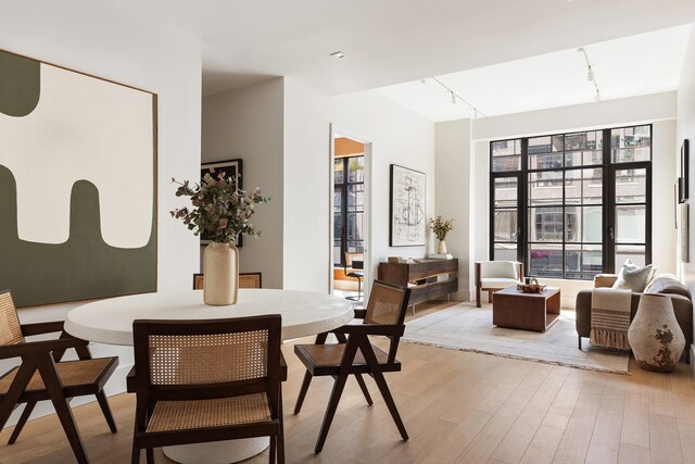 517 W 29th St Unit 8B, New York City, NY 10001 - dining area with rail lighting, healthy amount of natural light, and light wood finished floors