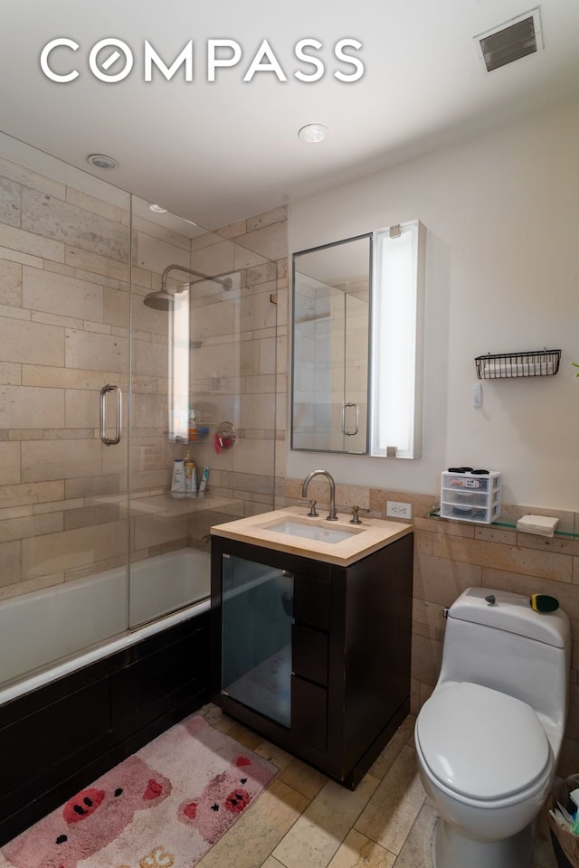450 E 83rd St Unit 5F, New York City, NY 10028 - bathroom with tile walls, bath / shower combo with glass door, and vanity