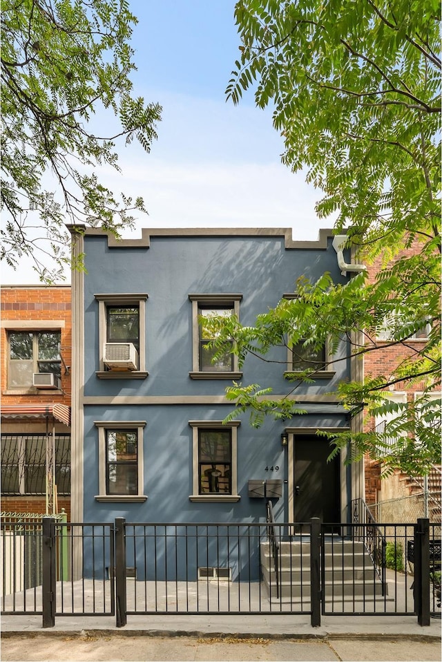 449 Pulaski St, New York City, NY 11221 - view of home's exterior featuring a fenced front yard, stucco siding, and a gate