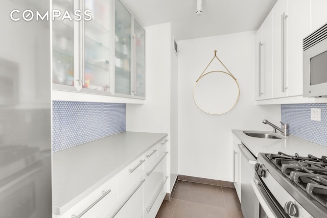 201 E 17th St Unit 31E, New York City, NY 10003 - kitchen with appliances with stainless steel finishes, decorative backsplash, light countertops, and white cabinetry