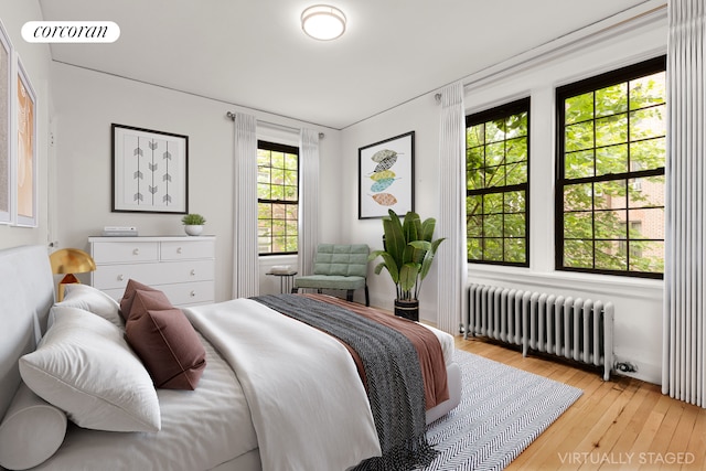 6 Burns St Unit 220, New York City, NY 11375 - bedroom featuring radiator heating unit and light wood-style flooring